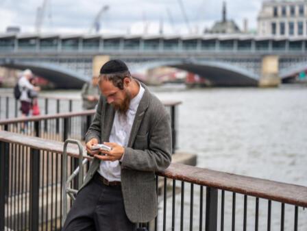 An Orthodox Jew reading from his mobile phone
