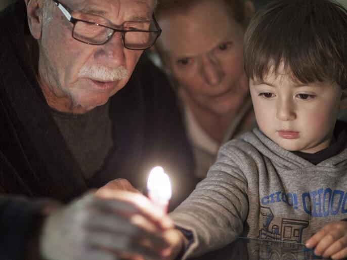 Jewish family lighting a candle