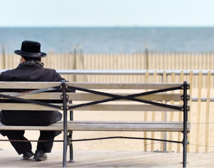 A Haredi man sitting on a bench