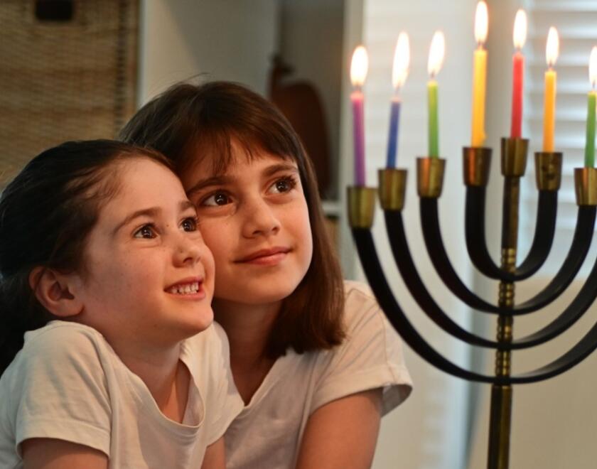 Jewish girls lighting a Menorah