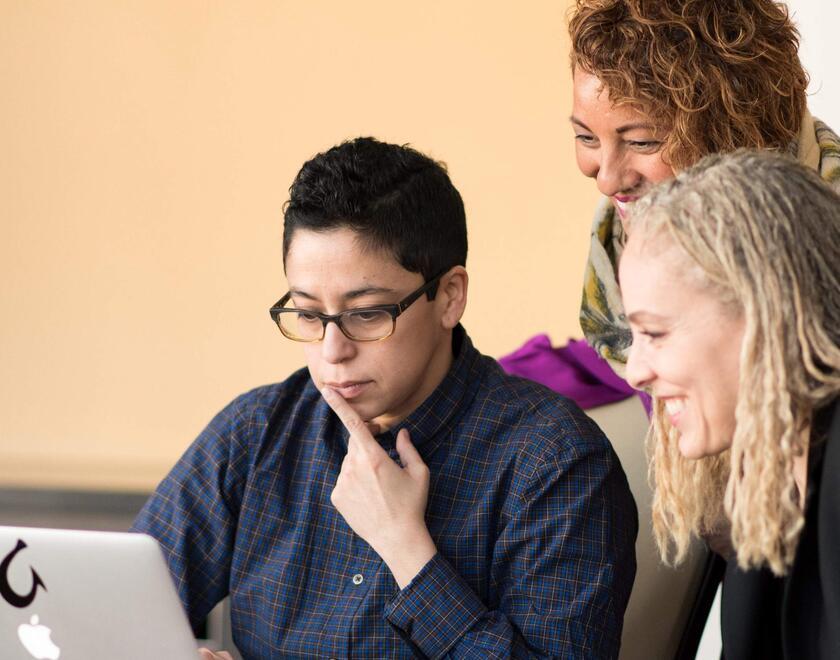 Women of various ethnicities working over laptop