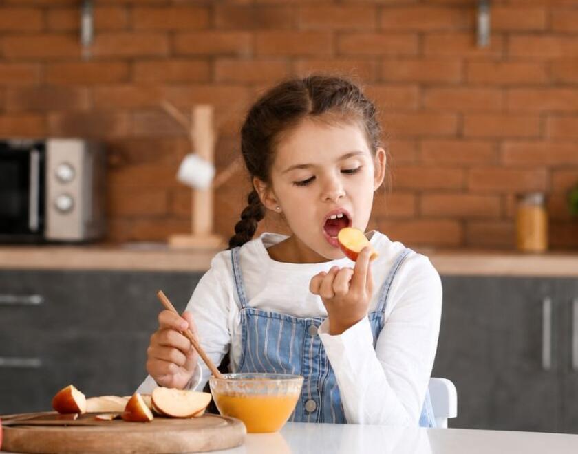 Girl eating apples and honey