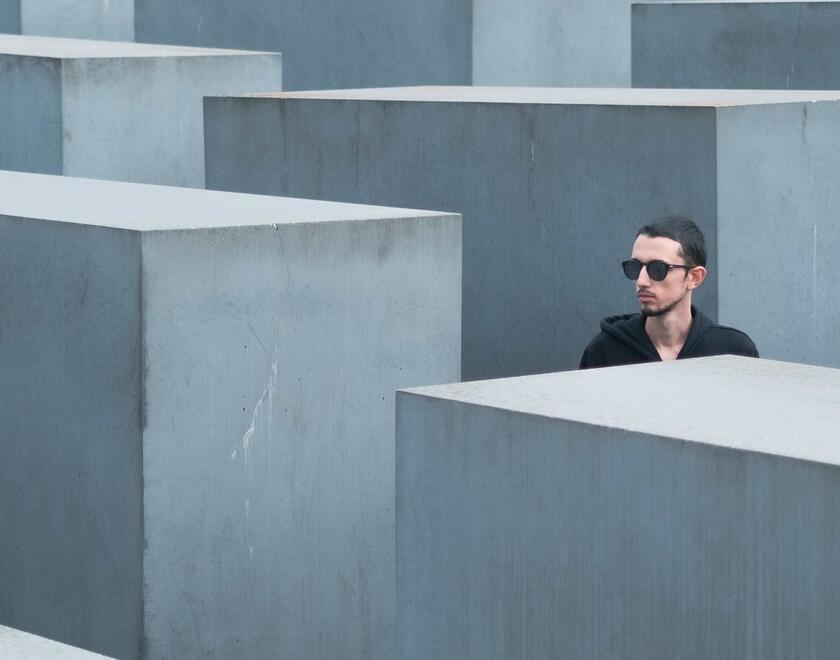 A young man visiting the Holocaust memorial in Berlin